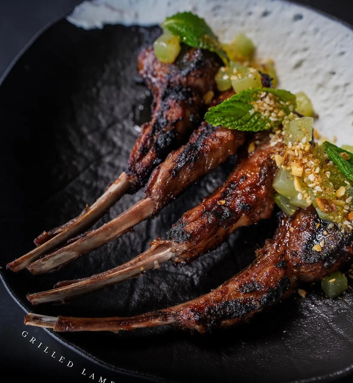 Charcoal-grilled lamb lollipops with mint and pickled grapes