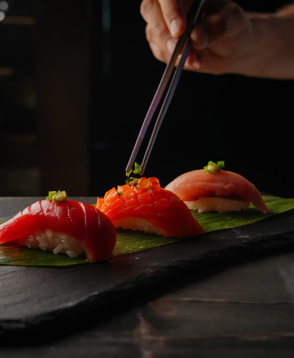 Torched tuna and salmon nigiri on a banana leaf