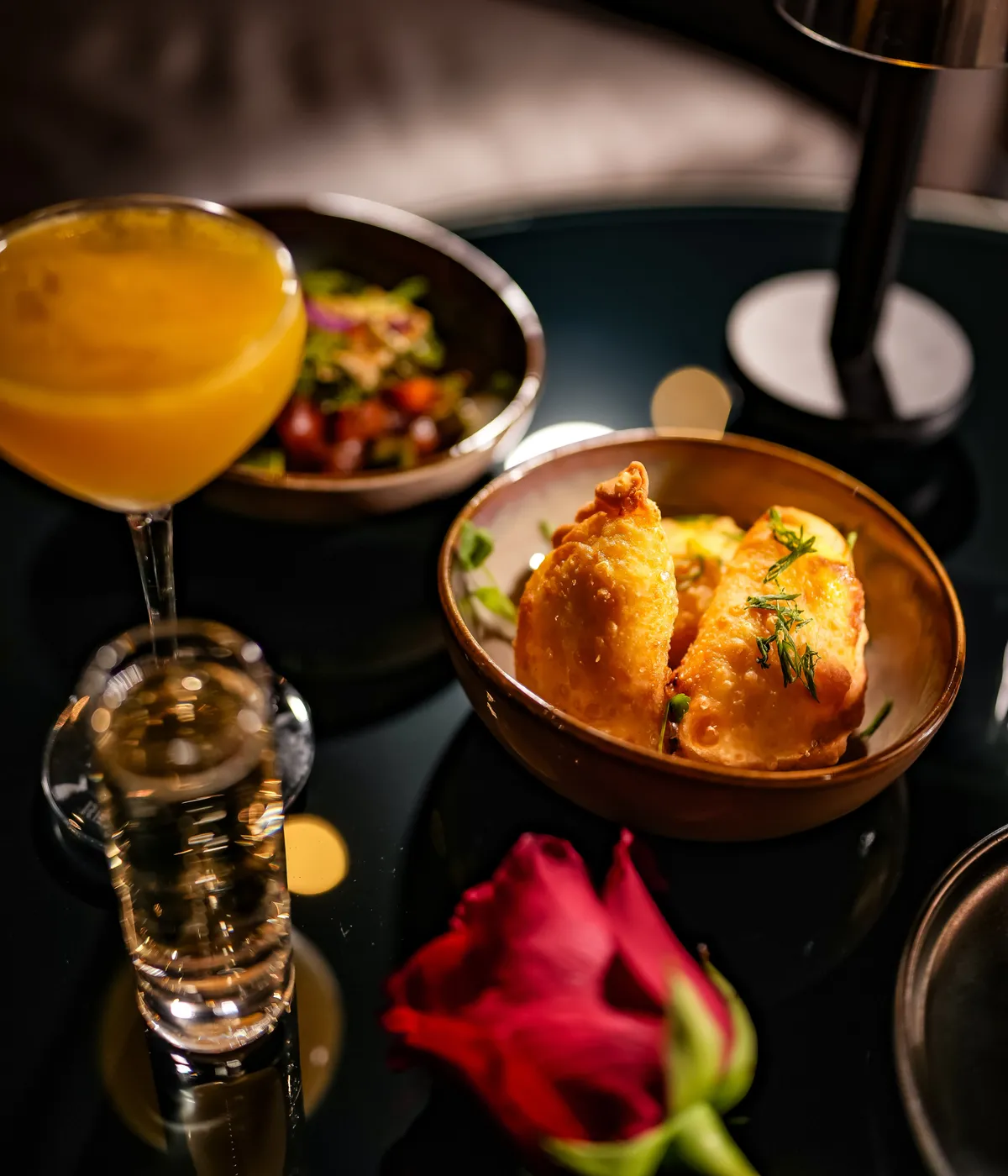Empanadas served with a bright orange cocktail