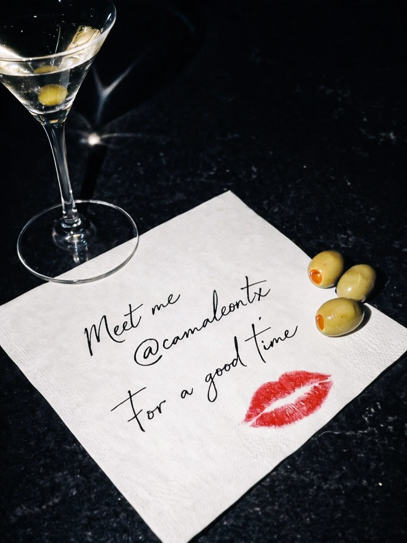 A cocktail napkin at Camaleón: “Meet me @camaleontx for a good time”