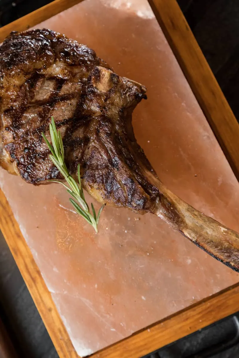 Grilled tomahawk steak served on a Himalayan salt block