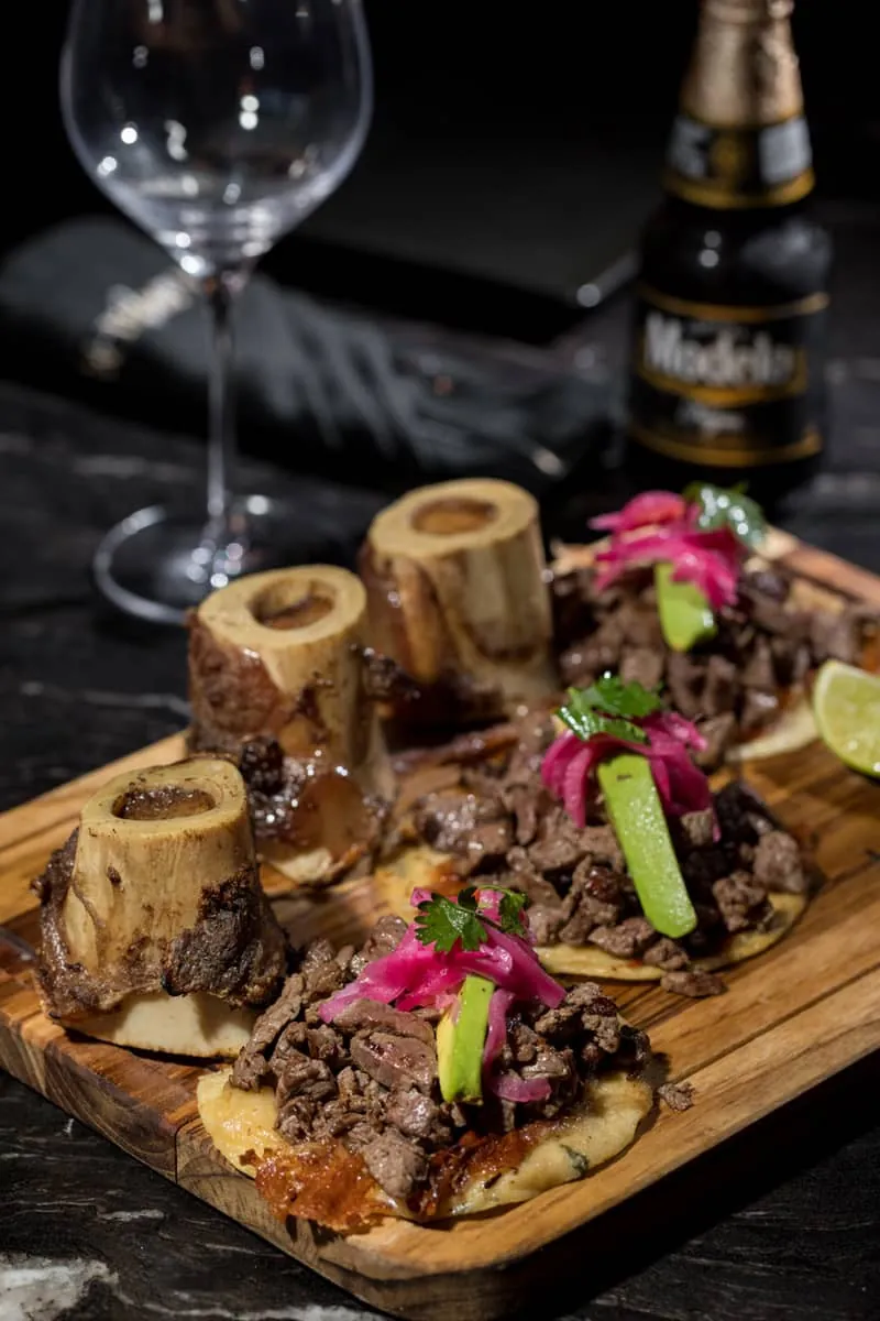 Roasted bone marrow with beef tacos and pickled onion