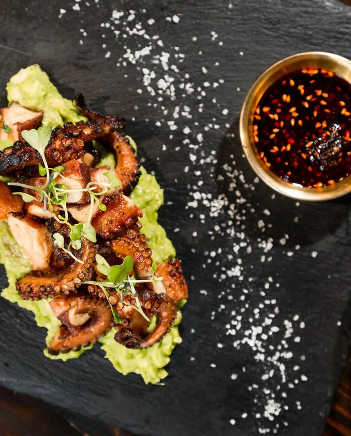 Charred octopus over avocado with chili oil