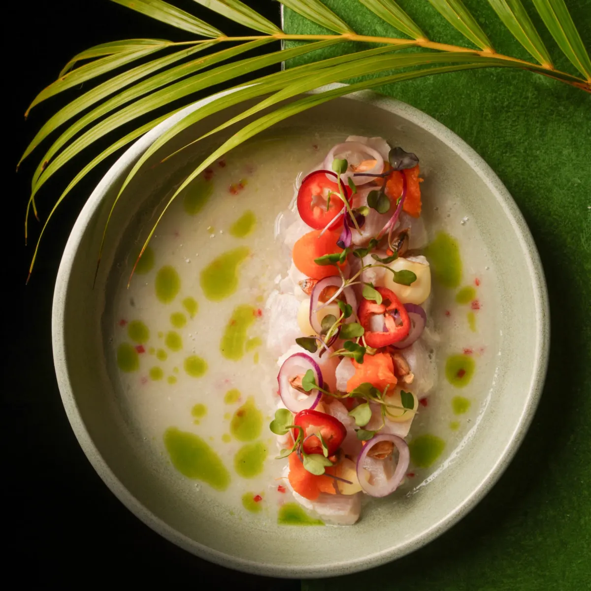 Tiradito of white fish in leche de tigre with cherry tomatoes and ají oil
