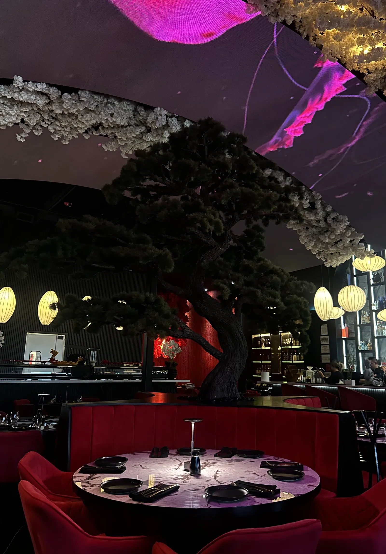 MOUSAI's dining room under paper lanterns with the sculpted tree at its center, McAllen