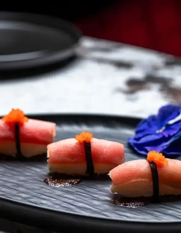 Hand-crafted nigiri topped with tobiko on black slate