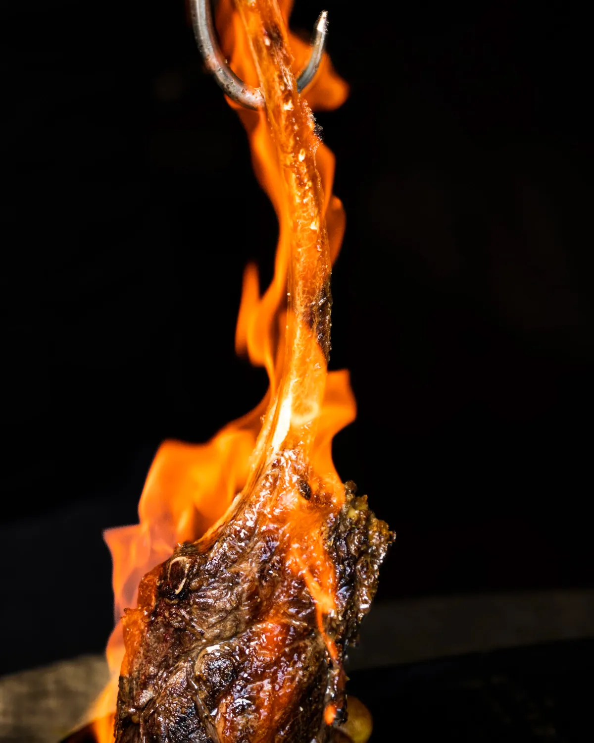 Tomahawk steak engulfed in flames on the grill