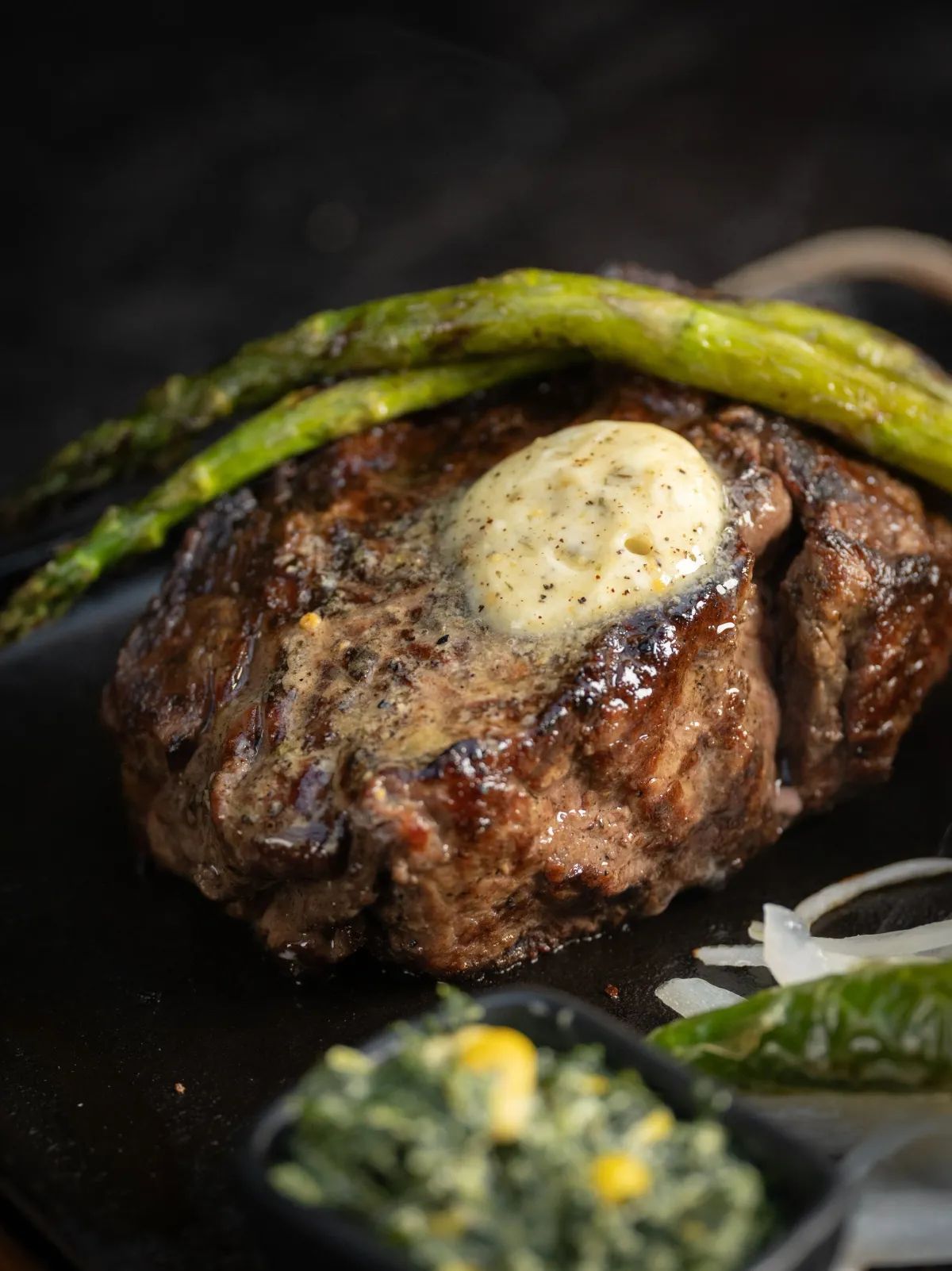 Ribeye topped with herb butter and grilled asparagus