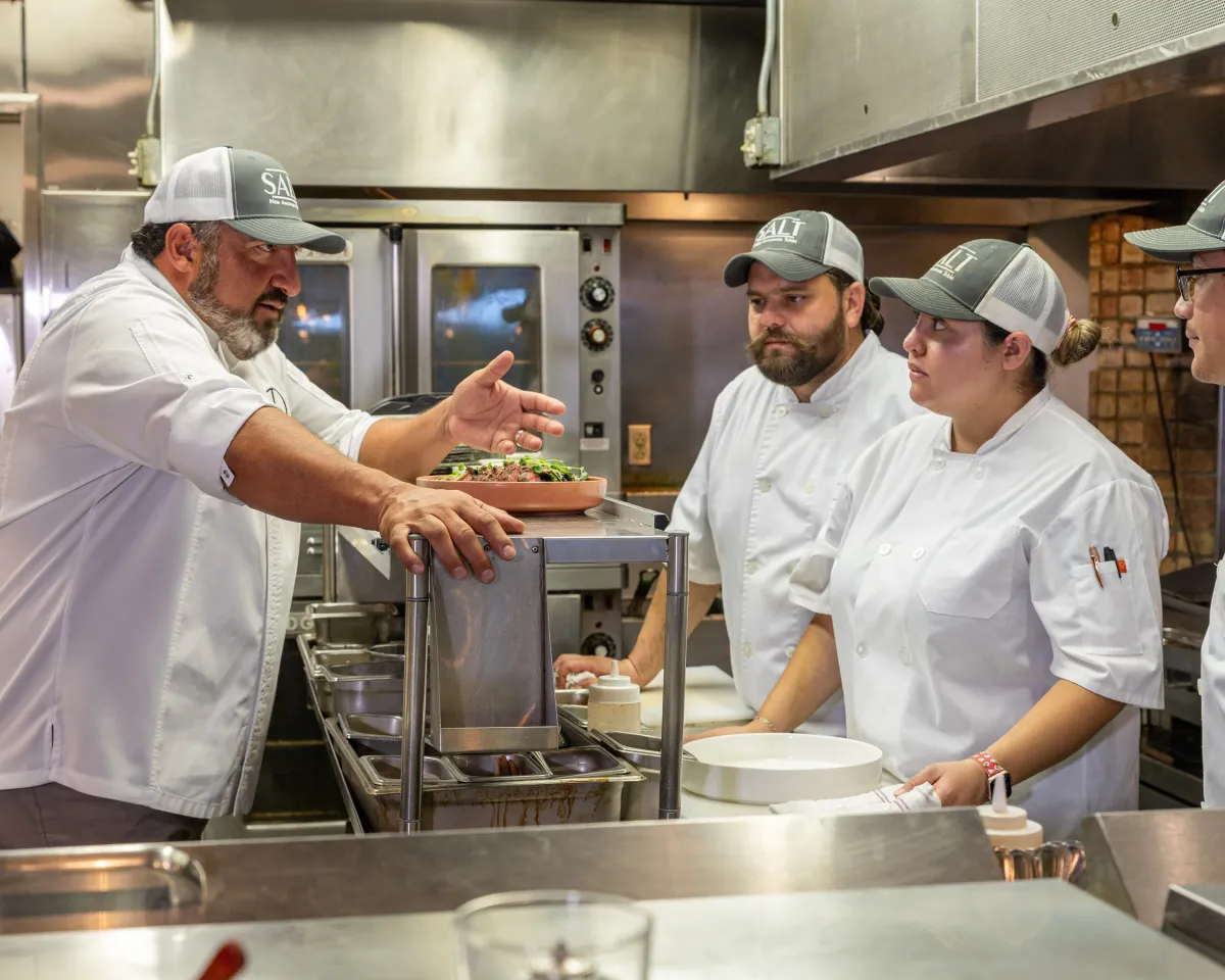 Chef Larry Delgado briefing his cooks on the line at SALT