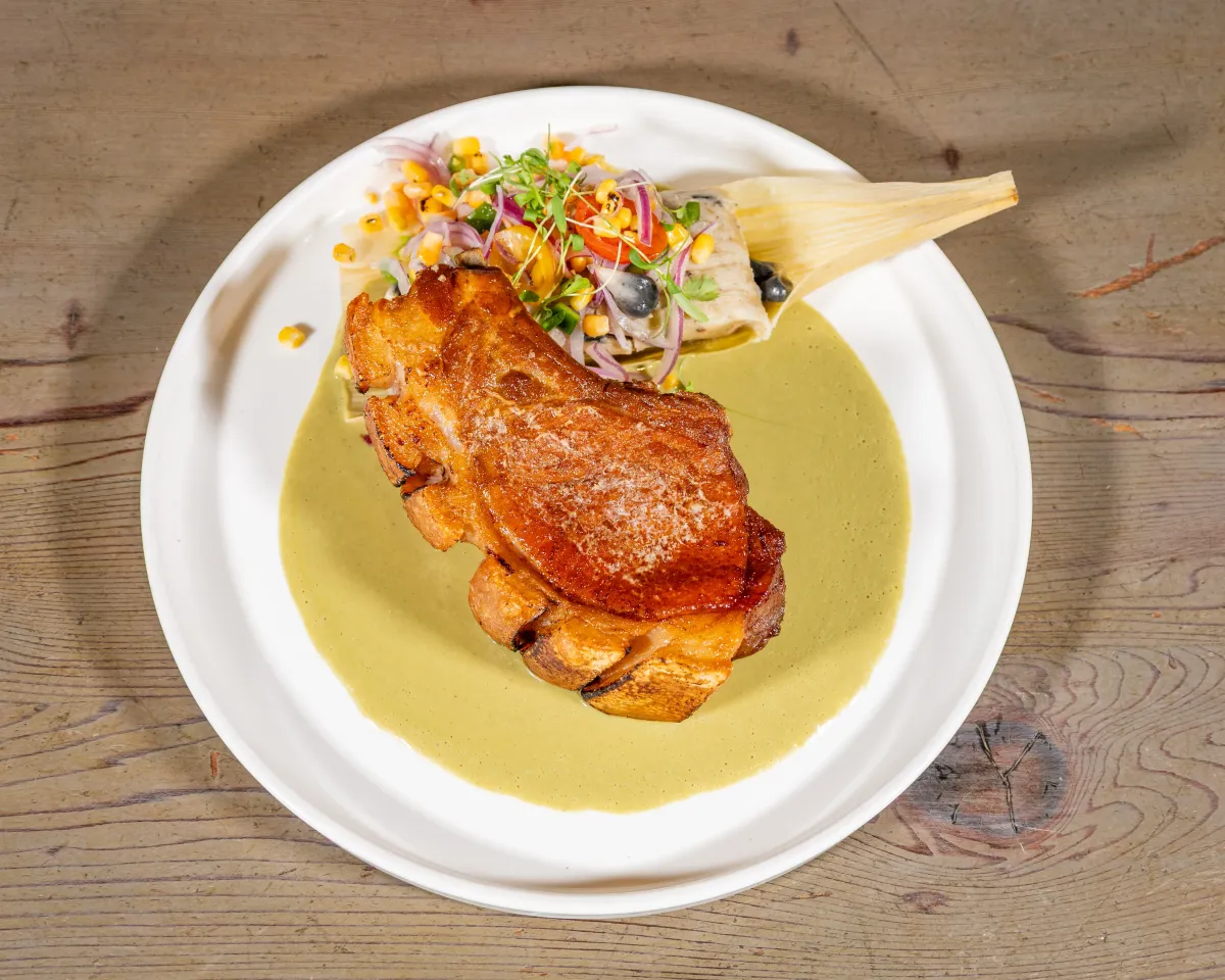Bone-in pork chop over a green tomatillo sauce