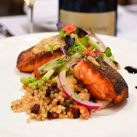 Seared salmon over Israeli couscous with pickled red onion