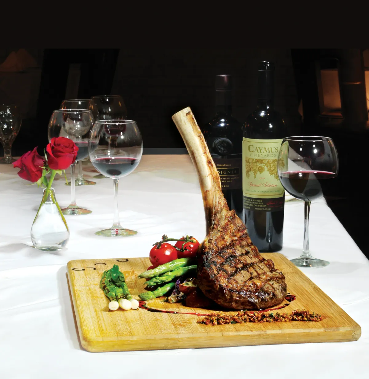 Tomahawk ribeye on a wooden board with red wine