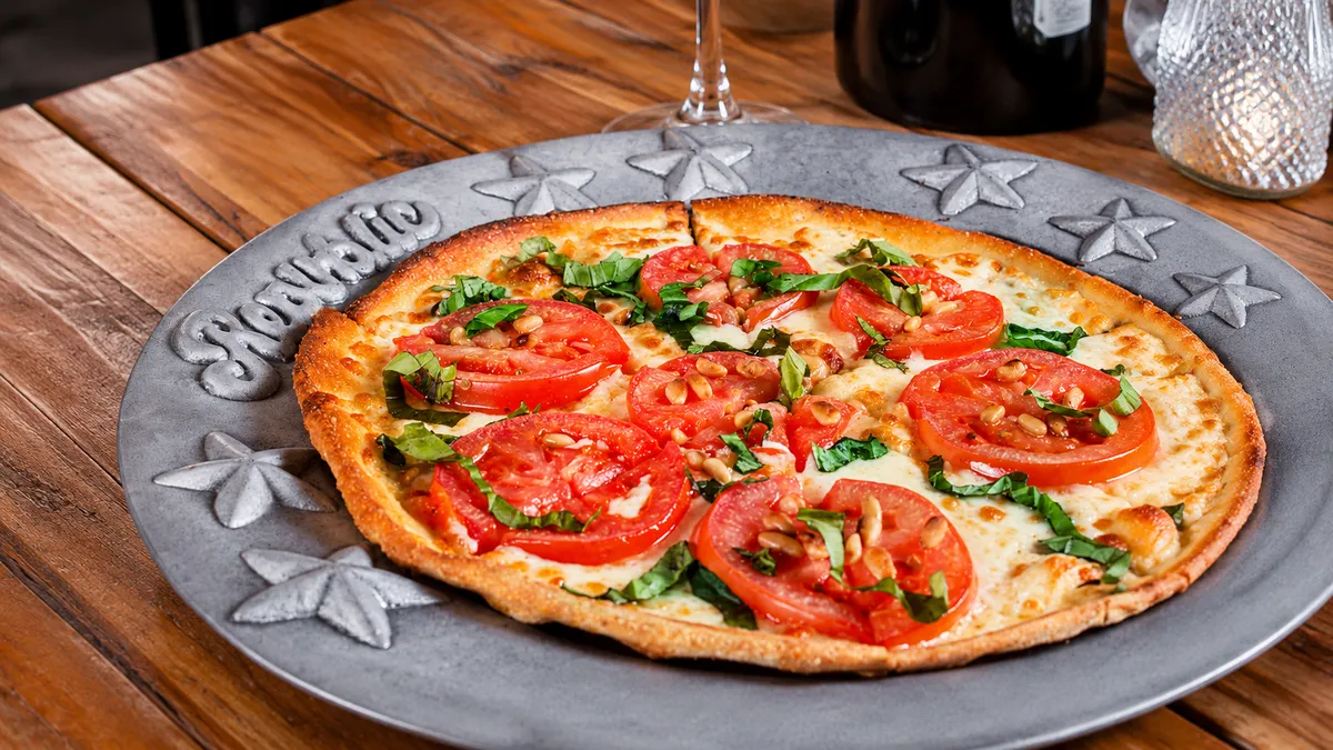 Margherita pizza with sliced tomato and basil